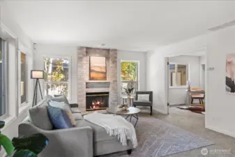 Living room features a cozy brick-accented fireplace and adjoining bonus movie room for relaxation or play.