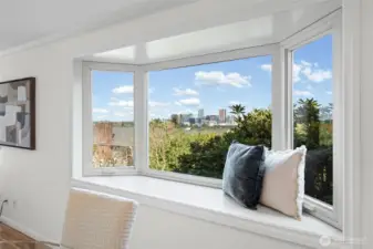 Framed by a stunning bay window, take in sweeping views of the Bellevue skyline from the comfort of your own home. Crisp white millwork, crown molding, and a spacious window seat create the perfect spot to relax and enjoy the scenery.
