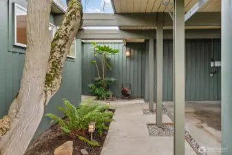 Welcoming covered entry with serene landscaping and architectural detail creates a private, inviting approach. Thoughtfully designed pathway and lighting set the tone for this stylish Bellevue residence.
