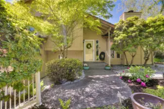 Take advantage of the mature shrubbery creating a welcoming front entrance or trim back growth to let in more light and showcase the charming, covered porch and decorative front door.