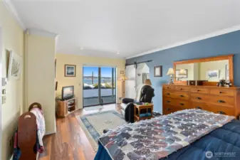 Primary bedroom w/sitting area, walk in closet and views out of the slider to the patio. More of that beautiful flooring!