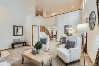 Vaulted ceilings in living room/dining space looking toward family room and up to 2nd floor loft bonus room.