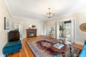 Bright living area featuring hardwood floors, a cozy fireplace, and timeless architectural details.
