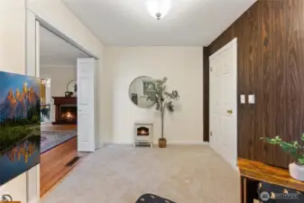 Comfortable den or office with plush carpet, neutral tones, and a view into the main living area.