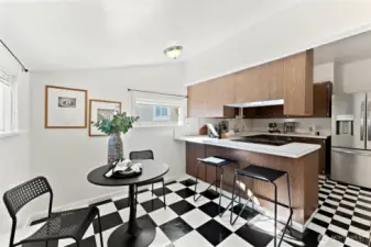Bright main floor kitchen with an eat-in dining space, black-and-white flooring, and natural light from multiple windows.
