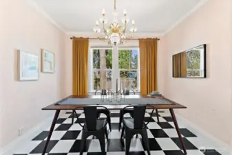 Elegant main floor dining room with chandelier lighting, large windows for natural light, and direct access to the kitchen.