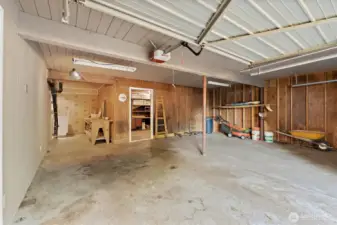 Spacious two-car garage with concrete floors, built-in workbench, and direct access to the basement shop for projects and storage.