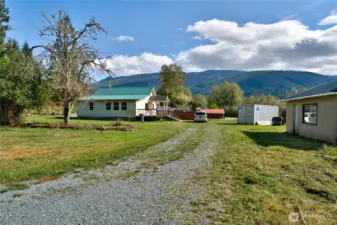 Level property with driveway parking, shed space to the right.