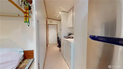The view from the kitchen towards the laundry area, mudroom, and door beyond to the garage.