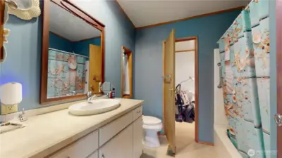 Another view of the primary bathroom with door leading to the mudroom beyond.