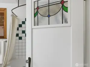 The character of the stained glass carries through on the bathroom door