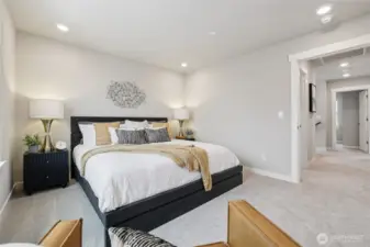 Primary bedroom with king sized bed - showing stage home in the community with the same plan.