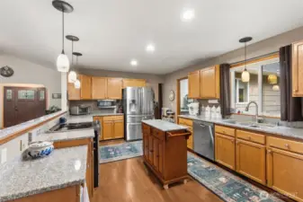 This kitchen was designed with baking, preparing meals and entertaining in mind! There is a dining area within the kitchen; or to the left of the fridge is an entry to a formal dining room which is currently used as a hobby-space. Doorway to the right leads to the spacious laundry room and garage entry.