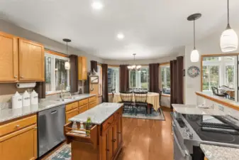 View from the kitchen toward the informal dining area. Kitchen window looks out toward the side yard. The bay window at the dining area with views through the sun room toward the back yard.