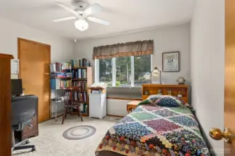 Bedroom #2 with view of back yard, walk-in closet. Carpeted floor.