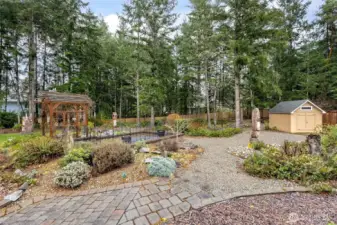 This property is a 3/4 acre lot. Partially wooded with areas for gardening, playing & relaxing. Storage shed included. This yard has several beautiful towering evergreen trees and selected a few to be thinned out. So she had the stumps that remained carved into nature sculptures.