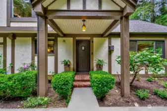 As you approach the front door, you're greeted by intricate details, decorative brickwork, and a quaint overhang supported by rustic timber beams.