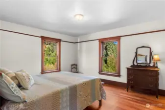 Primary bedroom with picturesque view of the sloping hills behind the home.