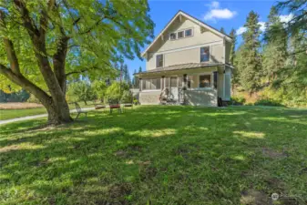 Home sits on nearly 2  acres of sloping green grass and shrubs, adorned with fruit trees.