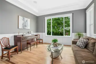 The living room is adjacent to the kitchen and features beautiful crown molding and refinished hardwood flooring.