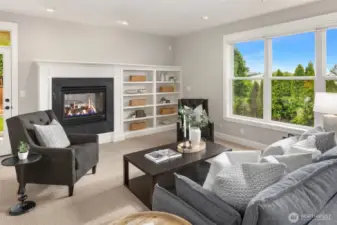Second living space with another gas fireplace and door leading to covered patio.