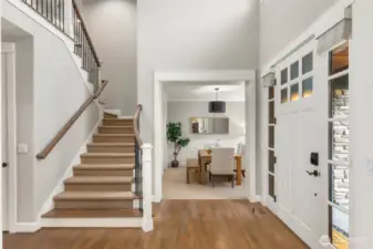 Welcoming entry with vaulted ceilings, open balcony, and bright interior.