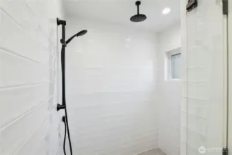 Large walk-in shower features rain shower head and handheld combo, making getting clean enjoyable!