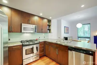 Well appointed kitchen with gas cooking opens to dining area and living room.