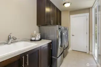 Laundry room with sink and storage cabinets