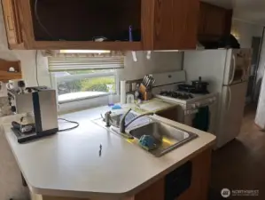 Kitchen with propane stove and full size refrigerator