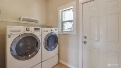 Laundry room is located on the main floor, with door leading to the backyard.