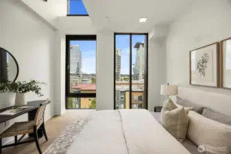 Primary bedroom features floor-to-ceiling windows, chevron engineered white oak floors and a walk-in-closet.