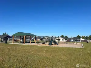 Private community park with covered picnic area, playground set, and swings.