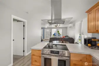Open concept living area view from kitchen into dining and living rooms.