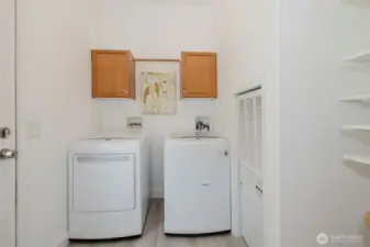 Laundry area with washer/dryer and storage space.