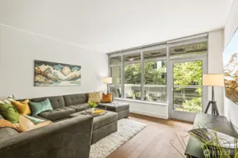 Floor-to-ceiling windows and a private covered deck that extends the living space.