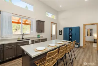 Open, light-filled kitchen with ample workspace, plus new front-entry storage cabinets for coats, hats, and shoes.