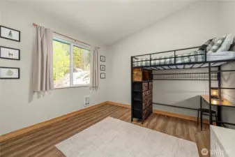 Bedroom 2 features a vaulted ceiling, full-size closet, and views of the backyard.