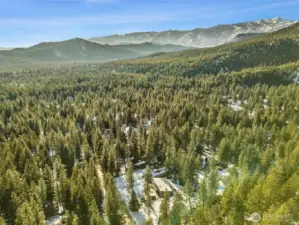 Surrounded by stunning mountains, this idyllic community offers endless recreation—skiing, golfing, river rafting, hiking, biking, boating, snowmobiling, and more—all just minutes from your door. Home pictured near bottom center of frame.