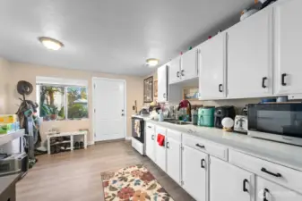 Unit 3 - Refreshed kitchen with LVP flooring, painted cabinets, quartz counters, and newer hardware.