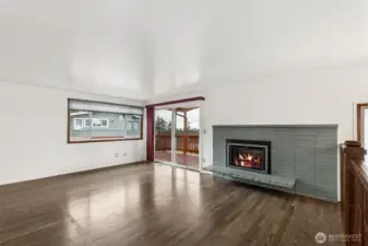 Living Room: Bright and airy living space featuring a gas fireplace and oversized sliding glass doors that perfectly frame the puget sound and territorial views.
