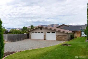 Street side of the house, garage with detached entry into the house. Garden Area in the fence to the right