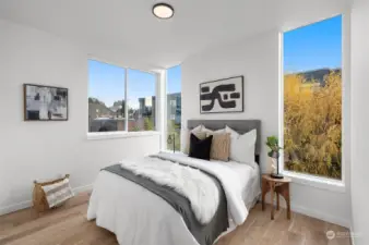 Wake up to serene views from this secondary bedroom, featuring floor-to-ceiling windows and ample natural light. It is a perfect sanctuary to start and end your day.