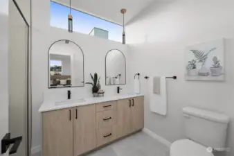 This stylish bathroom features a double vanity with sleek finishes, elegant pendant lighting, and thoughtful touches for your daily routine to feel like a spa experience.