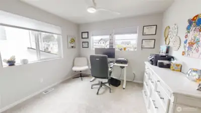 Bedroom with walk in closet with windows facing both the front and side of home for plenty of natural lighting.