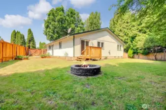 Backyard looking at the home with fire pit and stairs to dining room.