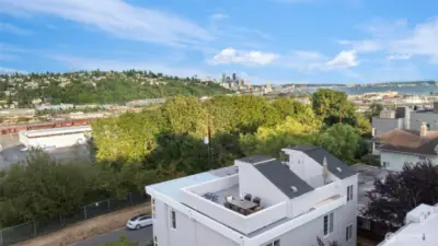 Drone shot of rooftop deck looking toward downtown Seattle, Elliott Bay and Queen Anne Hill