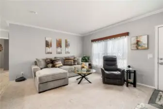 The living room feels light and comfortable with plush carpet underfoot and large double-paned vinyl windows that bring in plenty of natural light.