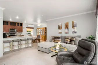 Crown molding and recessed LED lighting add a polished touch to the open layout, making the living and kitchen areas feel bright and welcoming.