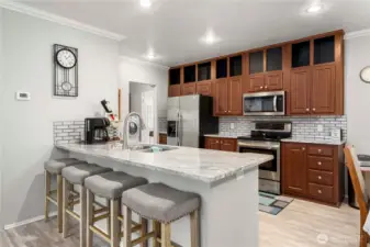 The granite peninsula with seating for four creates an easy, everyday spot for meals, coffee, or catching up while cooking.